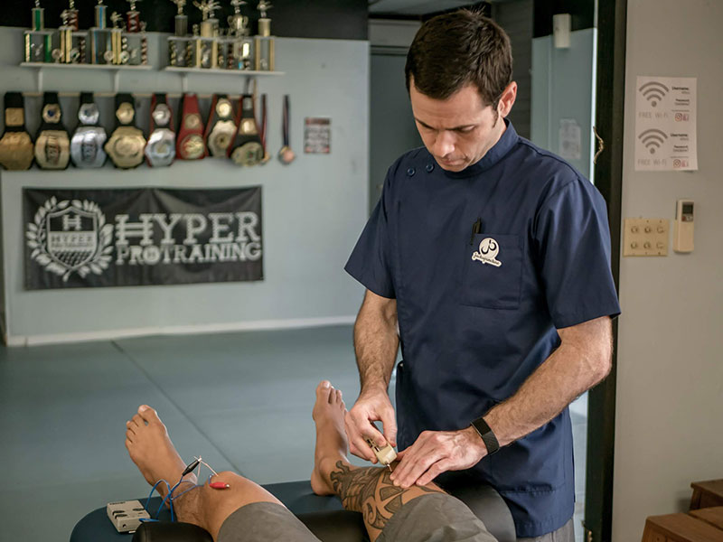 Jack performing precise acupuncture techniques, enhancing muscle recovery and promoting holistic health.