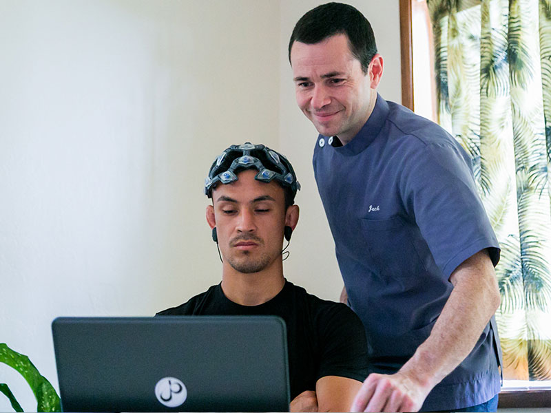 Jack guiding a client through PeakMind neurofeedback therapy, blending advanced technology with holistic healing.