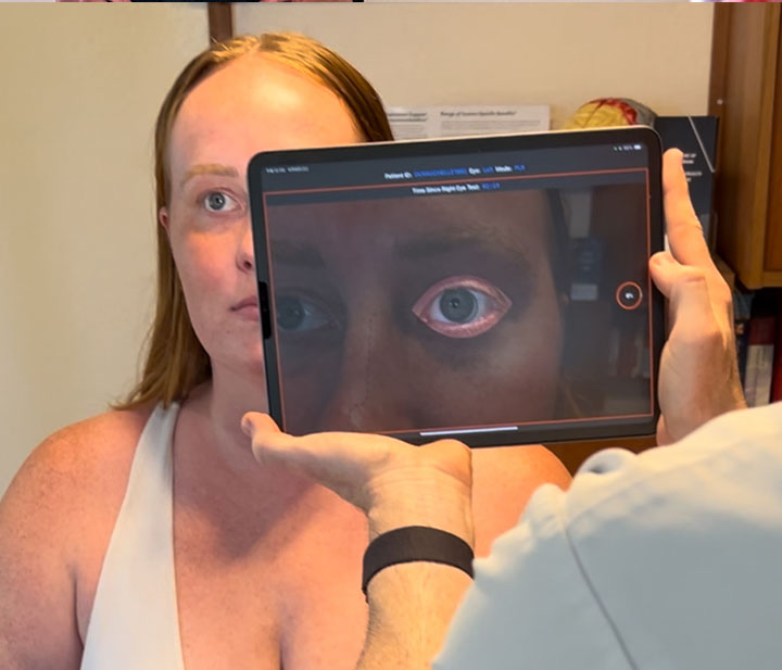 Jackupuncture practitioner using EyeCloseup-Snap technology to analyze eye health for precise and personalized treatment plans.