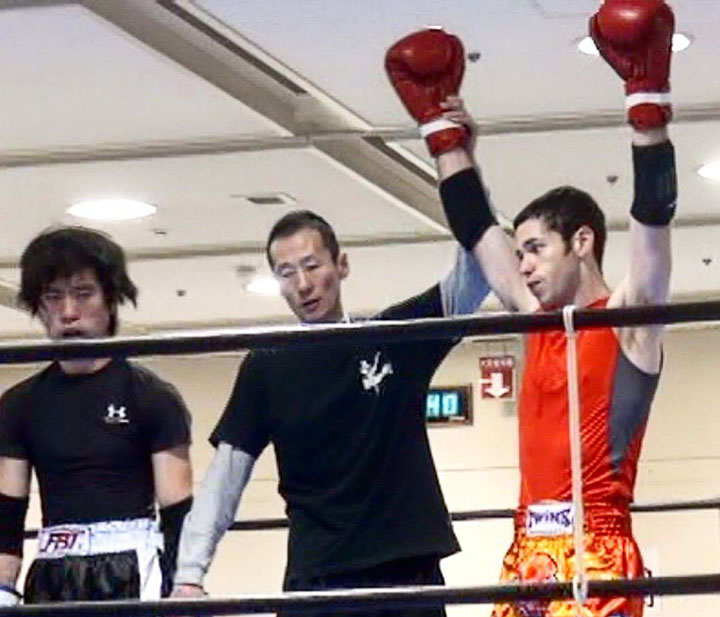 Jackupuncture athlete celebrating a victorious fight in the ring, showcasing peak performance and recovery techniques, captured with Fight-Snap.