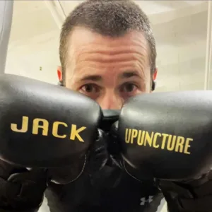 Jackupuncture founder wearing custom boxing gloves, showcasing the fusion of fitness and holistic wellness.