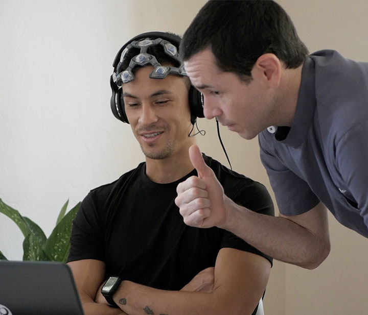 Jackupuncture practitioner guiding a client through PeakMind neurofeedback training, enhancing focus and mental performance, captured with PeakMind-Snap.