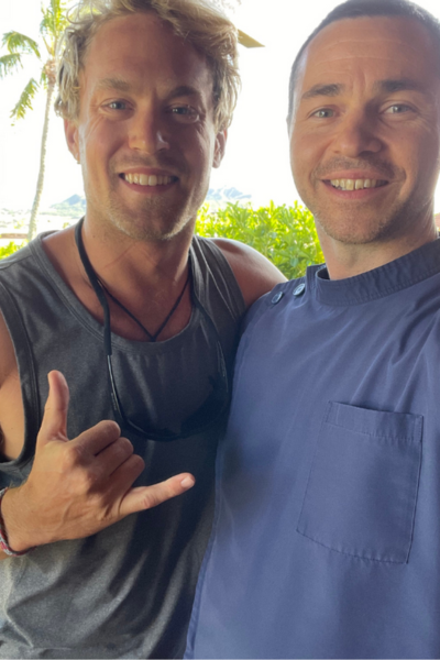 Jackupuncture practitioner smiling with a satisfied client, showcasing a positive and personalized wellness experience in a tropical setting.